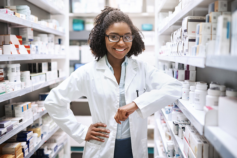 Student with white lab coat inside a pharmacy.