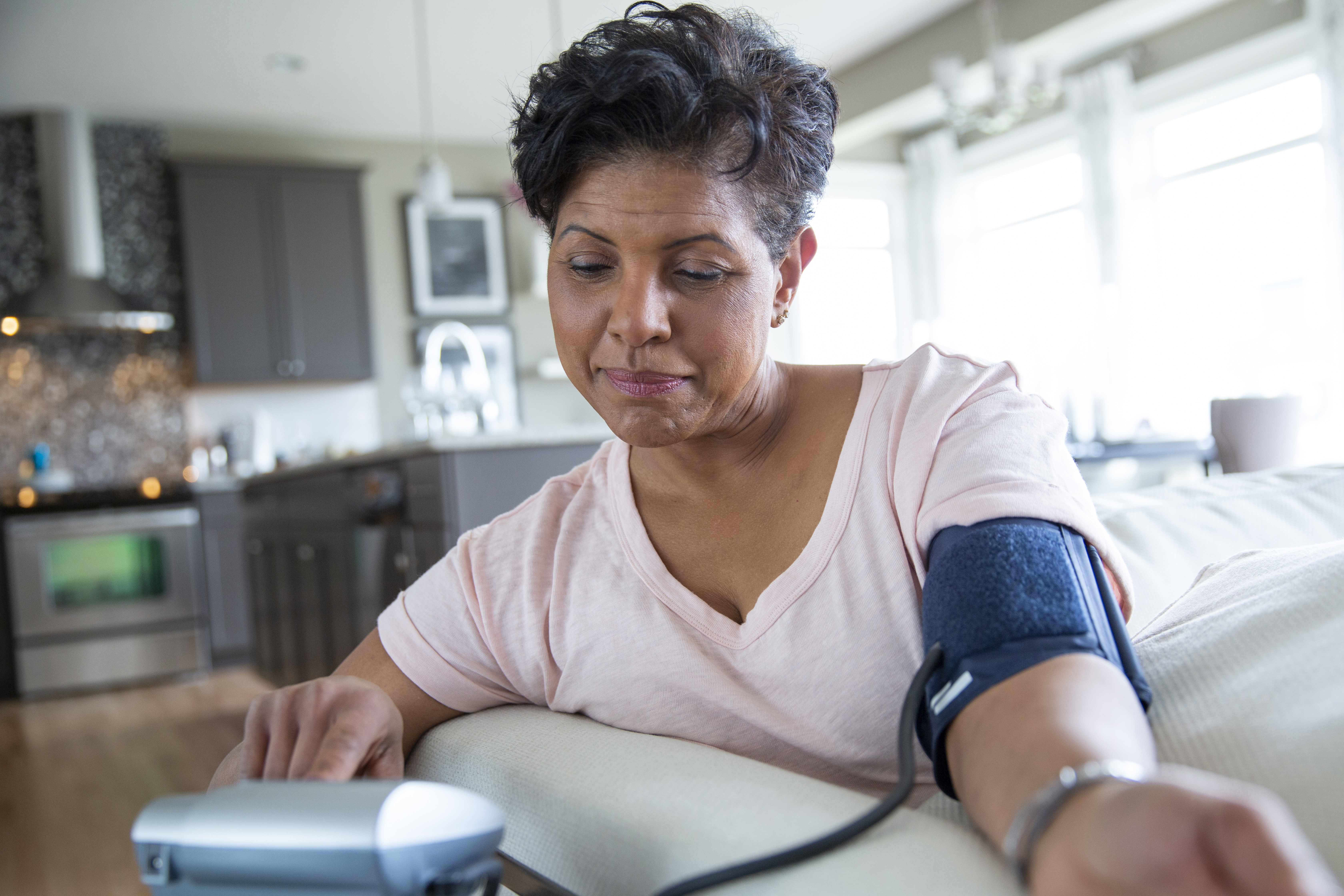woman using remote blood pressure cuff machine